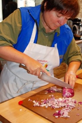 Viv Chopping Onion in Paella Cooking Class at Ateliers & Saveurs