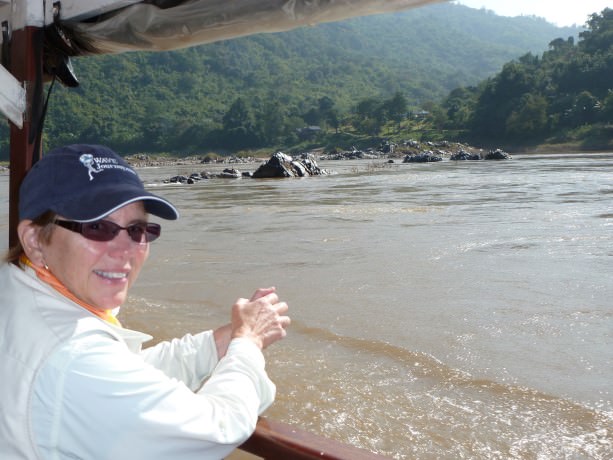 Jill takes in the scenery along the river banks of the Mekong in Laos.